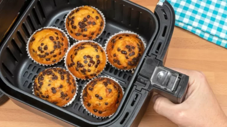 Bolo recém-assado sendo retirado de uma airfryer em uma cozinha doméstica.