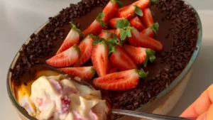 Bombom de morango na travessa com creme, morangos frescos e ganache de chocolate